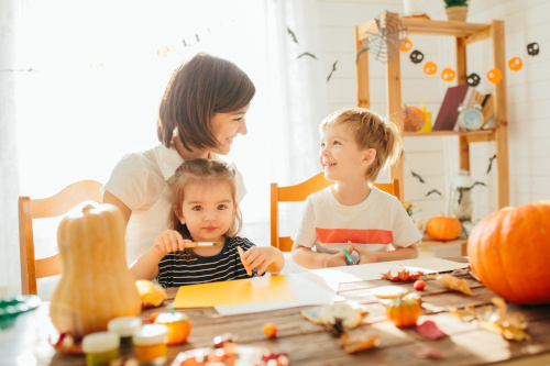 A family does crafts at their big, comfortable kitchen table.