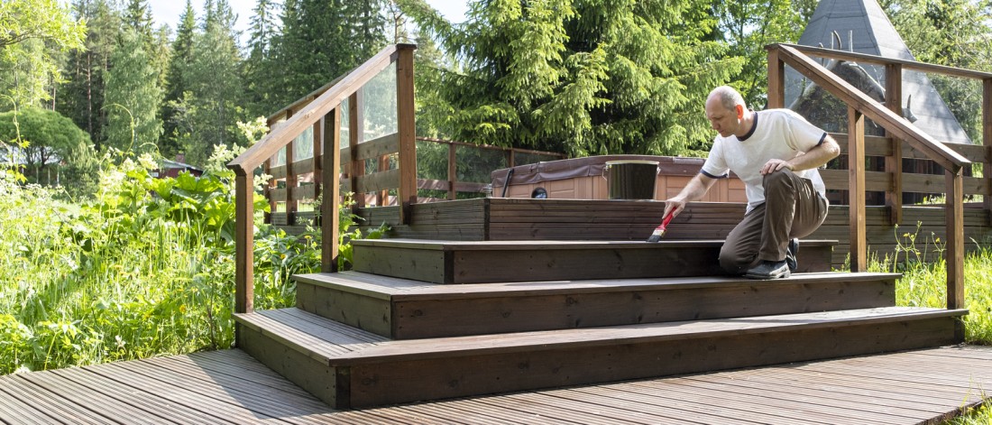 Photo of a man painting the deck