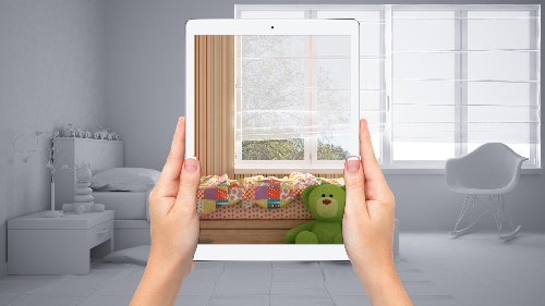 A gray background for a kids bedroom gets coloring through the lens of a tablet held in front of the room.