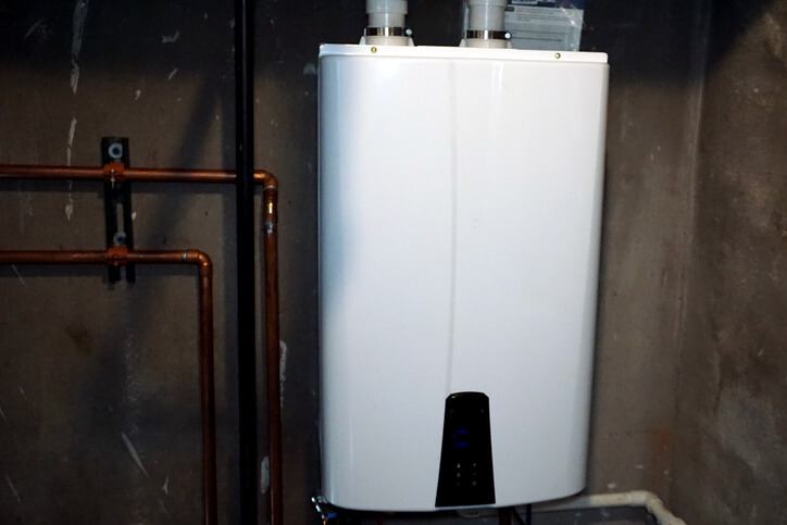 A small, tankless water heater rests on the wall in this homeowner's basement.